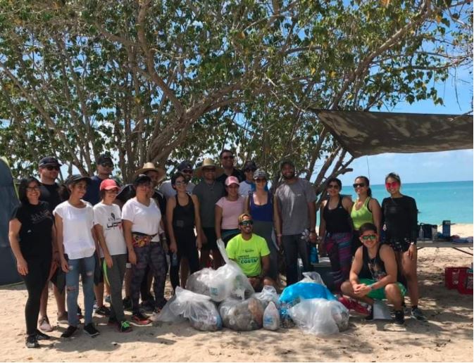 Grupo de estudiantes en área playa donde recogieron desperdicios